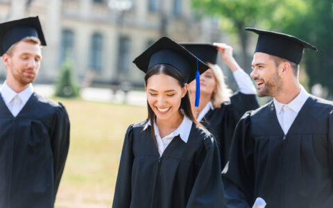 smiling-young-graduated-students-in-capes-on-unive-B5P5UC4